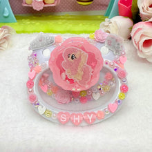 Load image into Gallery viewer, adult pacifier paci age regression item binky DDLG ABDL  with a cartoon character and 'SHY' text, surrounded by flowers and decorative elements.
